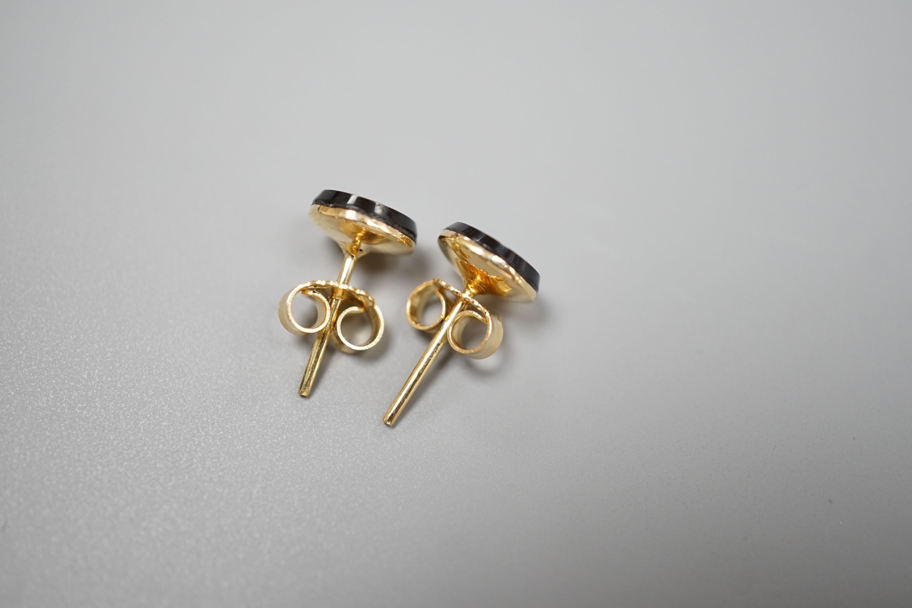 A pair of 750 yellow metal, black onyx and diamond set circular ear studs, 6mm, gross weight 1.8 grams.